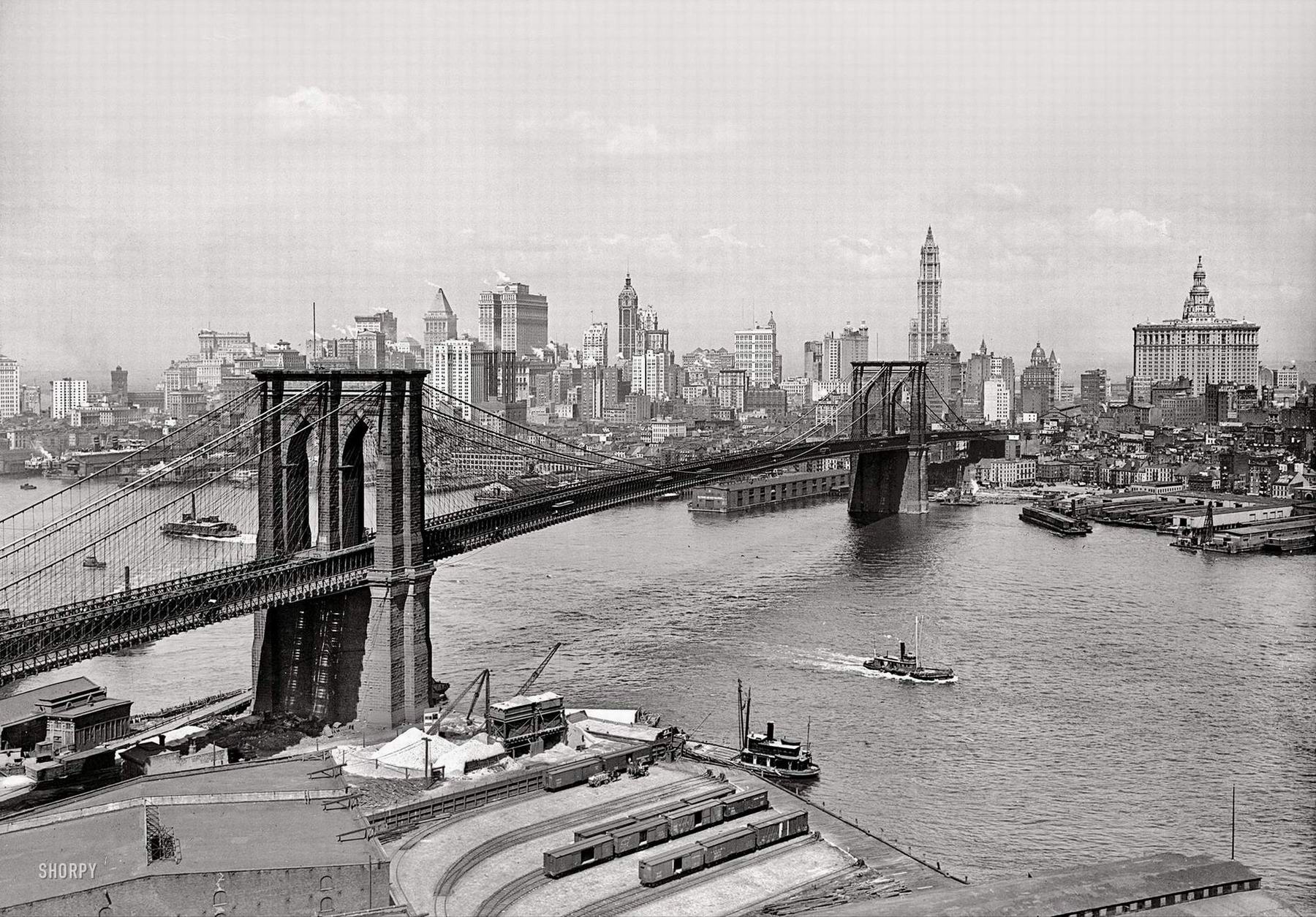 New York circa 1915. Brooklyn Bridge, East River. The Woolworth Building, Singer, Bankers Trust, Hudson Terminal, Municipal and Park Row buildings are visible.jpg