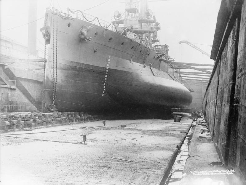 HMS GLATTON, in dry dock, note the substantial bulge and the paravane chains at her bow.jpg