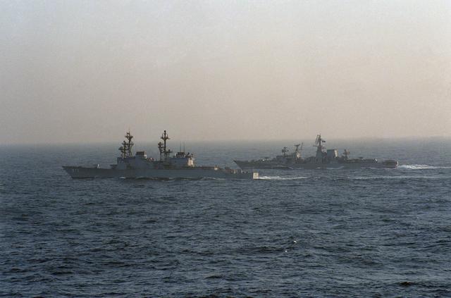 The destroyer USS JOHN YOUNG (DD 973), foreground, screens a Soviet Kara class guided missile cruiser during operations with the nuclear-powered aircraft carrier USS CARL VINSON (CVN 70)..jpg