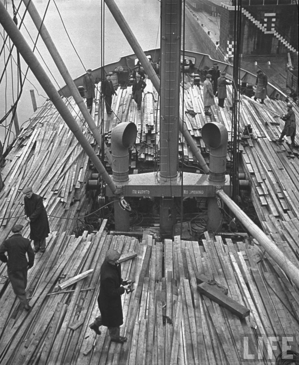 Dock workers unloading timber from the Russian ship.jpg